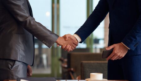 Two people performing a handshake in business suits